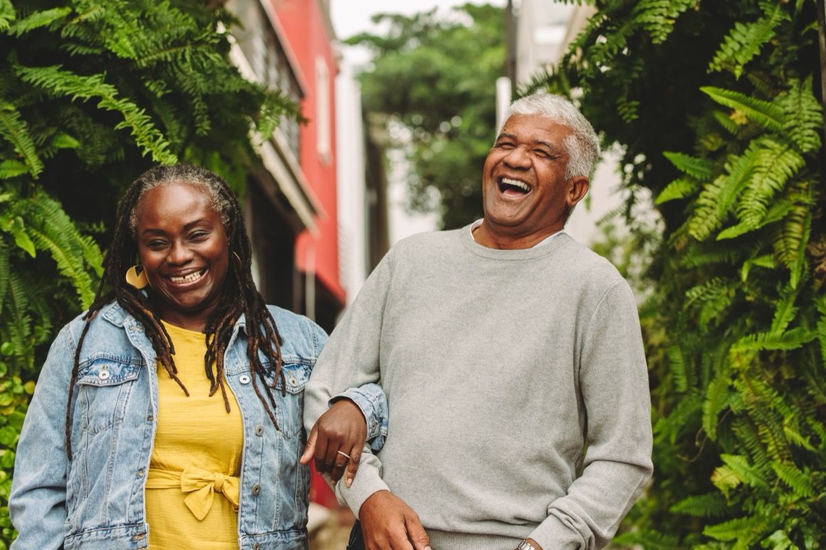  man and woman linking arms while walking outside