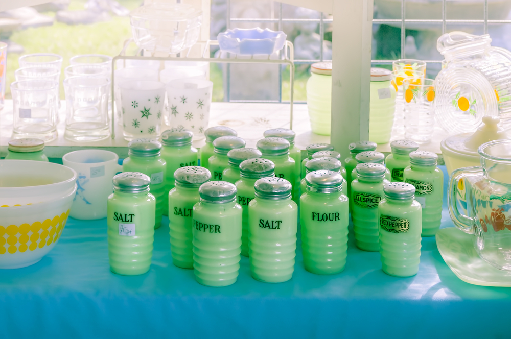 A lineup of jadeite spice and ingredient containers on a table at a flea market