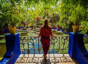 A woman standing in front of a pond at the Jardin Majorelle