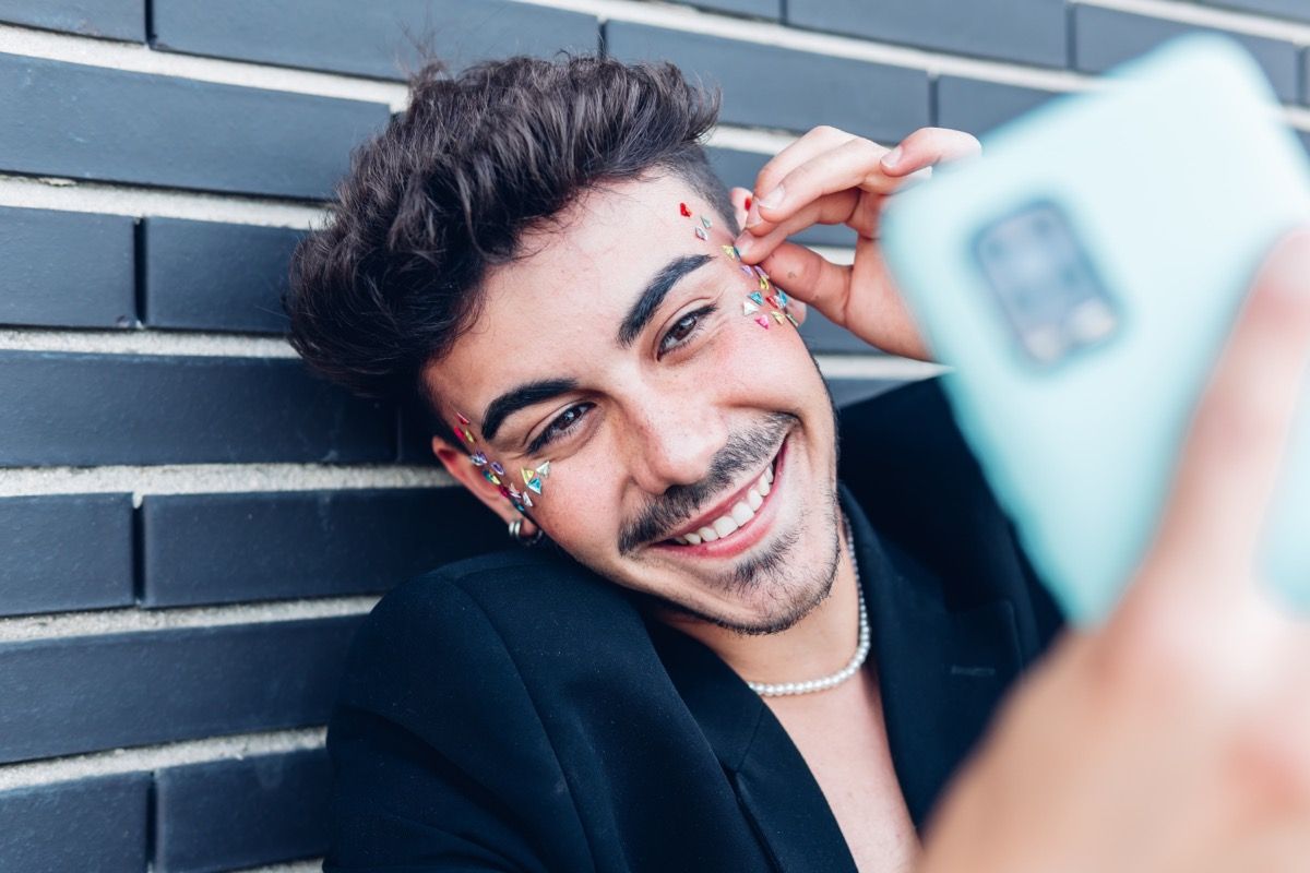 young man with stickers around his eyes on FaceTime