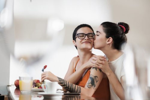 two woman embracing at the breakfast table