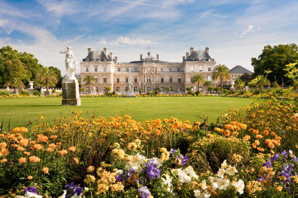 A long view of the Palais Luxembourg and the Luxembourg Gardens in Paris, France with flowers in bloom