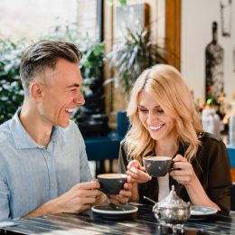 Happy cheerful caucasian middle-aged couple spouses drinking coffee talking enjoying romantic date together in cafe restaurant bar