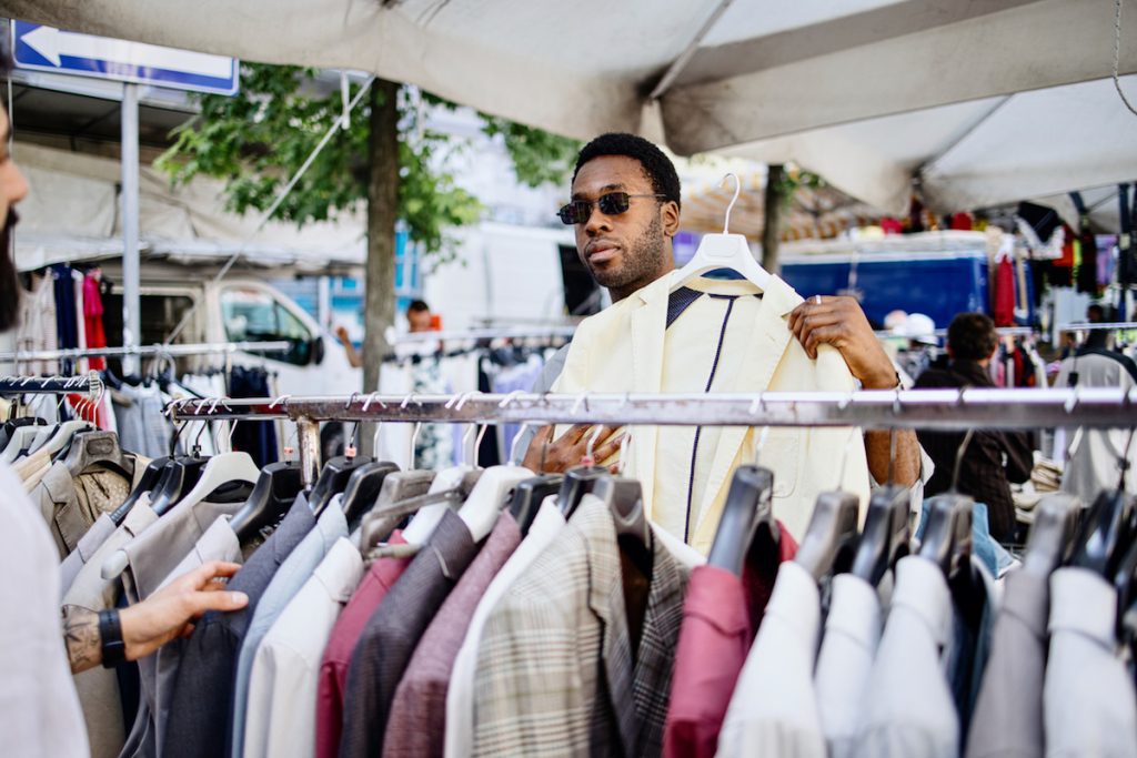 Male friends shopping in a secondhand market in summer