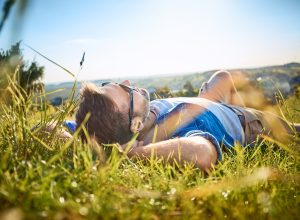 Man lying in grass on hiking trip in the mountains