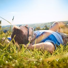 Man lying in grass on hiking trip in the mountains
