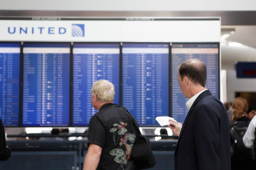 Passengers looking at United departures board