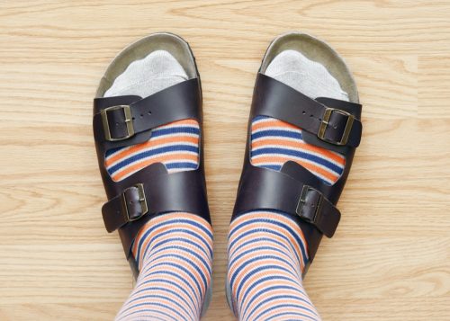 Closeup of a man wearing socks and sandals.