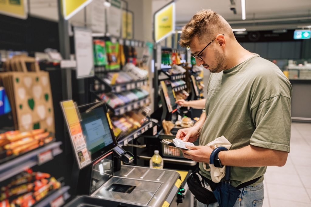 Man using self-checkout at supermarket