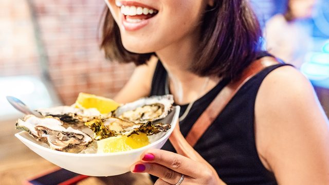 Woman,Eating,Oysters,And,Shellfish,In,Restaurant.,Delicious,And,Delicacy