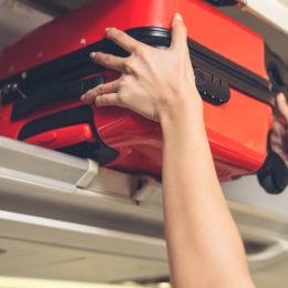 putting carry-on bag in overhead compartment