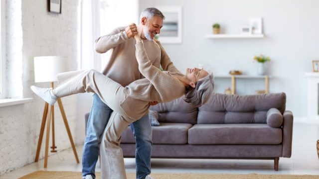 senior couple dancing in living room