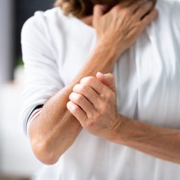 woman in pain holding arm