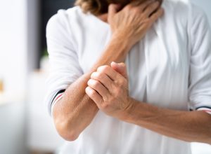 woman in pain holding arm