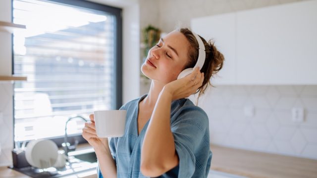 young woman listening to music in the kitchen