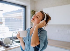 young woman listening to music in the kitchen