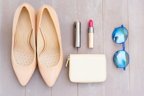 Nude pointy heels shoes with clutch, sunglasses, and lipstick