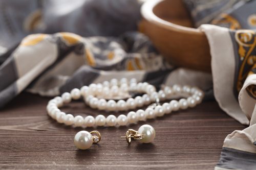 Accessories style concept with pearl earrings, necklace, and scarf
