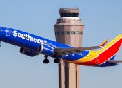 A Southwest Airlines airliner taking off with an air control tower in the background
