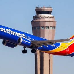 A Southwest Airlines airliner taking off with an air control tower in the background