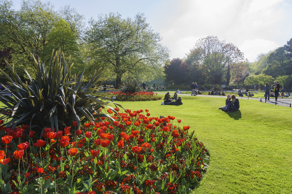A view of St. Stephen's Green in Dunlin with people sitting on grass