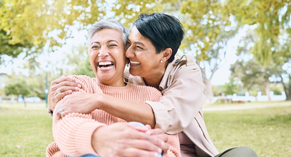 two women hugging in a park