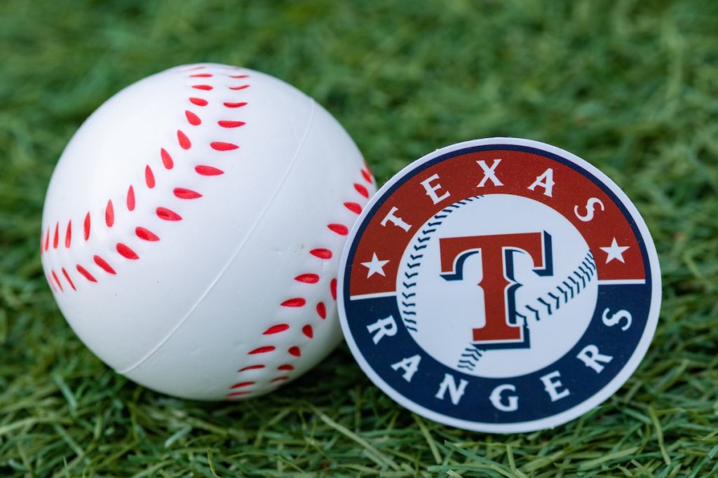 The emblem of the baseball club Texas Rangers and a baseball.