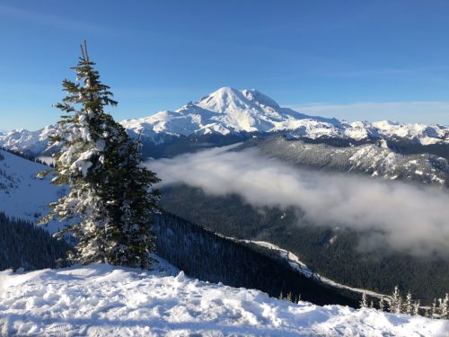 Beautiful view of snow covered Mt. Rainier in Washington State with blue sky in the background.