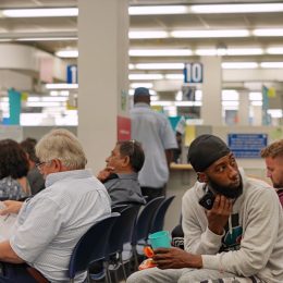 Snapshot of a bored crowd of people in the waiting area of a DMV