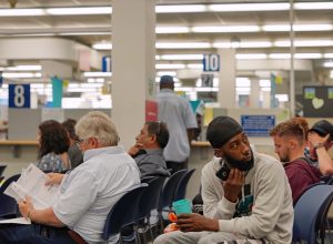 Snapshot of a bored crowd of people in the waiting area of a DMV