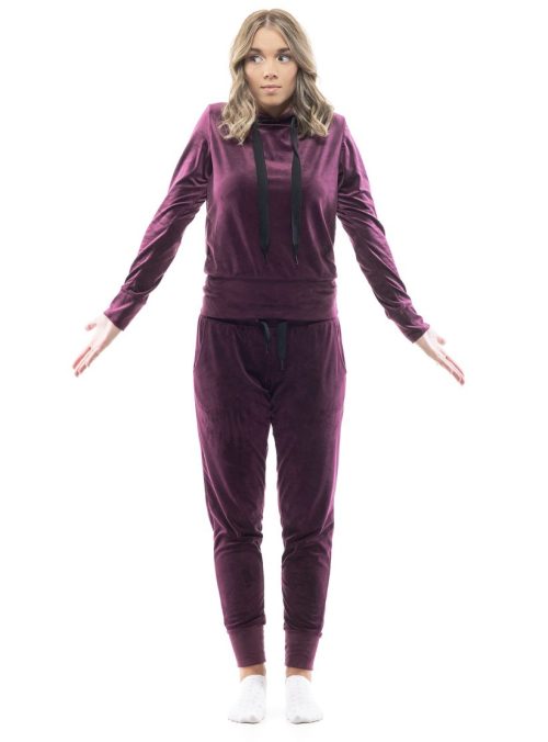 Confused cute young woman wearing a burgundy velour sweatsuit against a white background