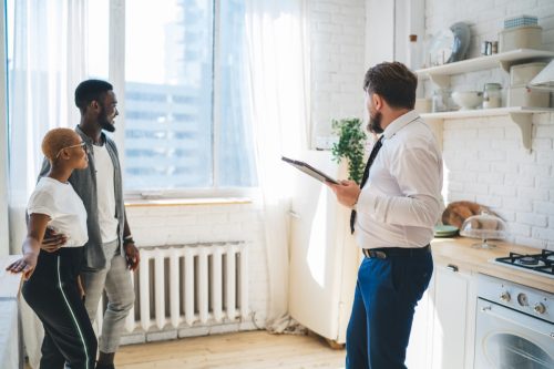 Man and woman looking at apartment with male leasing agent