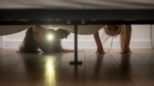 mother and daughter checking under the bed for monsters
