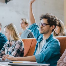 Young Male Student Raising Hand in Class