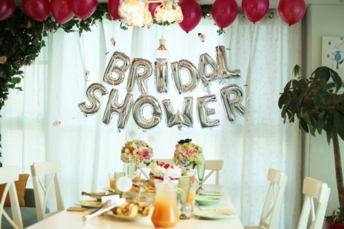 bride celebrating her upcoming wedding with balloons, table setting, and bridal shower games