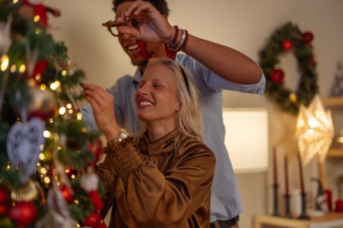 man and woman decorating the christmas tree