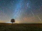 A wide shot of the night sky with dozens of meteors streaking