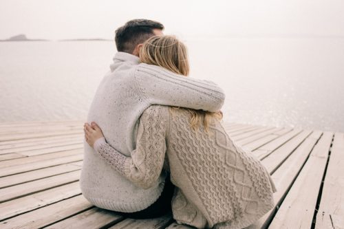 man and woman hugging on a pier