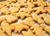 A view of a baking tray of dinosaur chicken nuggets.