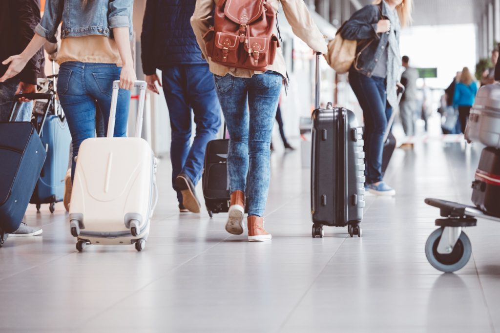 A group of travelers pulling suitcases through an airport