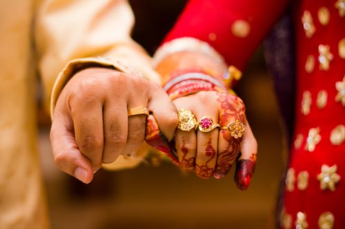close-up of a hindu bride and groom's hands during wedding