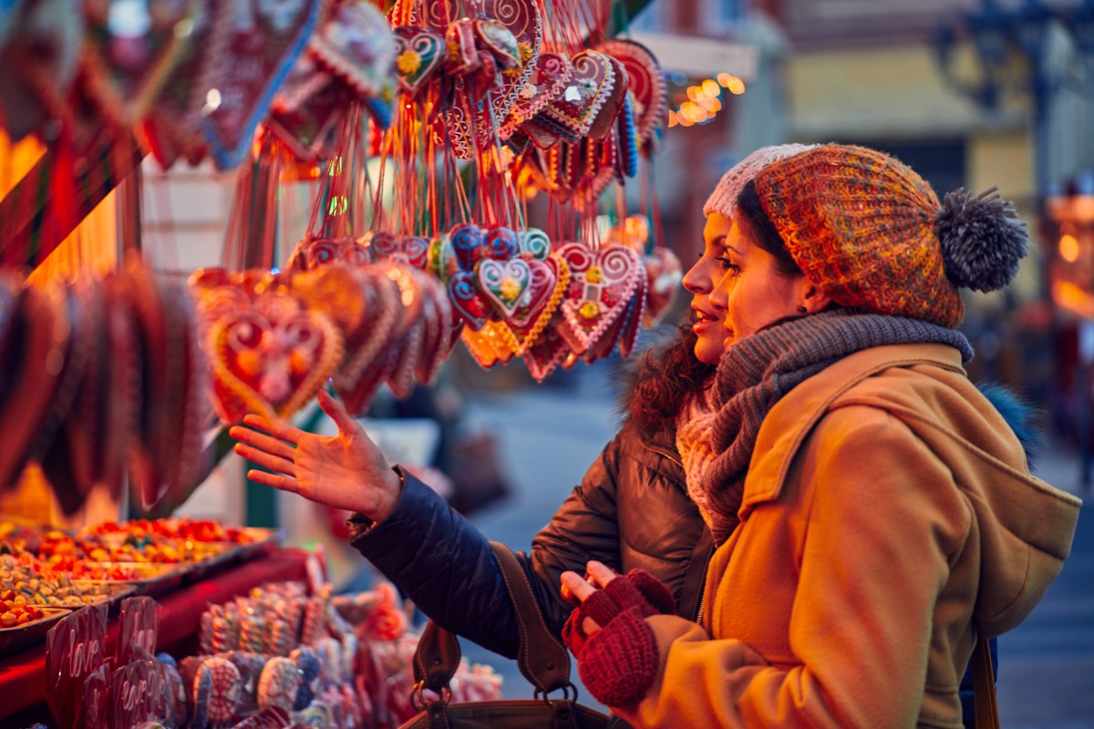 Two women browsing ornaments at holiday Christmas market