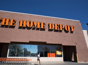 Santa Fe, NM: A man is about to enter The Home Depot near a line of orange shopping carts. The store is constructed in the Pueblo architectural style.