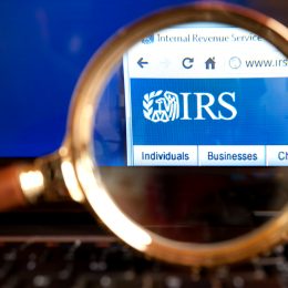 A close up of a magnifying looking at the IRS logo on the agency's website