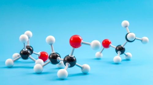 Molecular structure of chemical compounds and organic chemistry concept with educational plastic model of ethanol molecule isolated on blue background