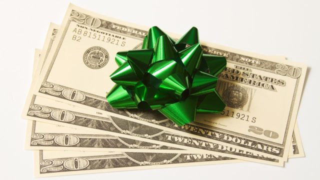 US currency money as a gift with a bow.