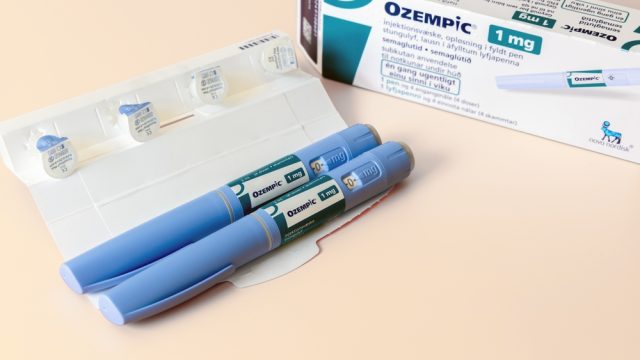 Two Ozempic pens next to their box and dose cartridges