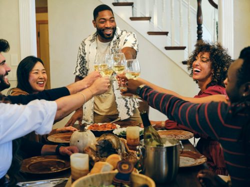 A group of friends celebrating Thanksgiving dinner together in a home.