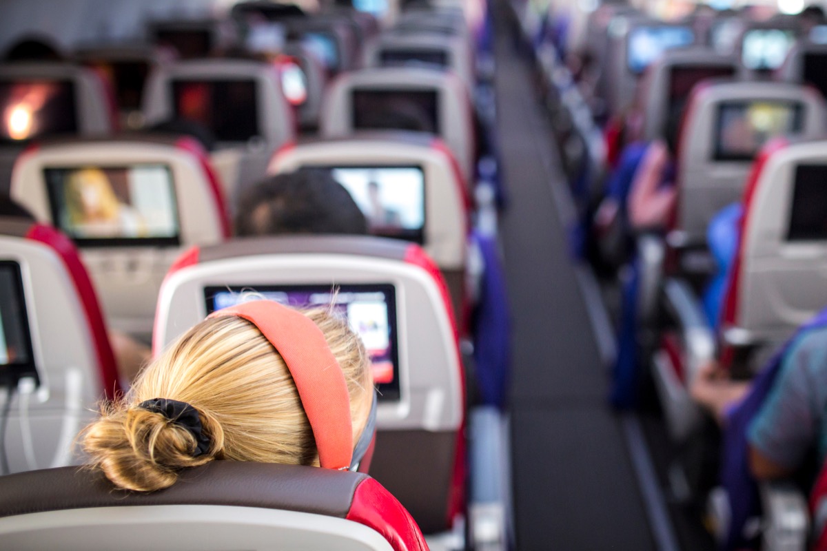 woman sitting in aisle seat on large airplane