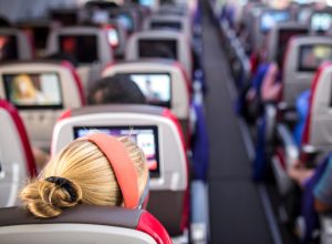 woman sitting in aisle seat on large airplane